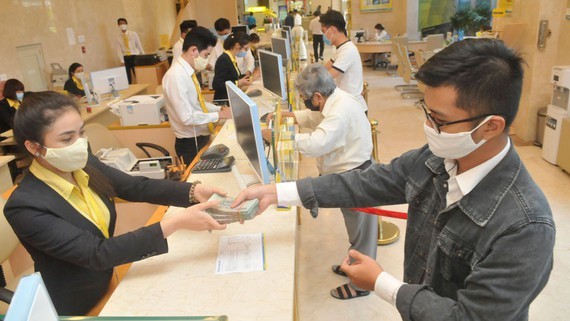 Customers do transactions at a commercial bank in Ho Chi Minh City. (Photo: SGGP)