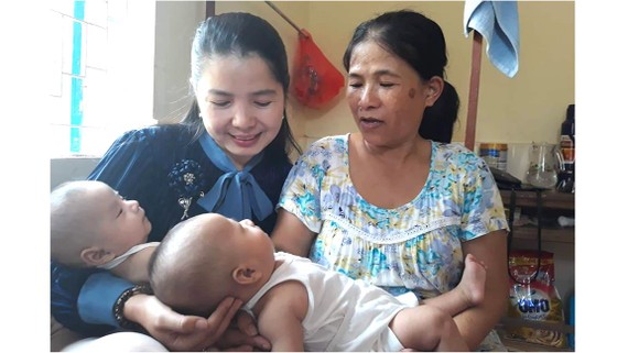 Nụ cười hạnh phúc của Lê Thị Thùy Na (bìa trái) bên cặp song sinh Thanh Bình và Tuấn Tú