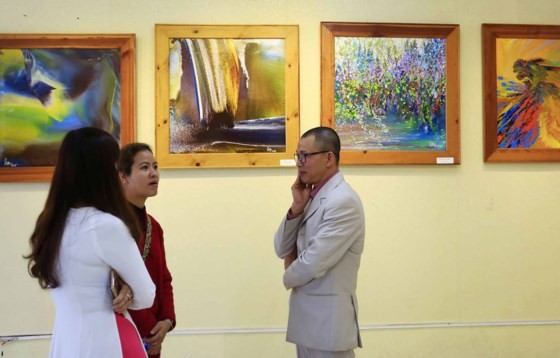 Painter Vo Trinh Bien ( R) at the exhibition (Photo: Sggp)