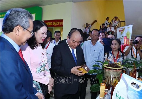 Prime Minister Nguyen Xuan Phuc visits an exhibition within the conference. (Photo: VNA)