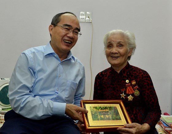 Secretary of the City’s Party Committee Nguyen Thien Nhan (L) visits Heroic Mother Le Thi Cach. (Photo: Sggp)