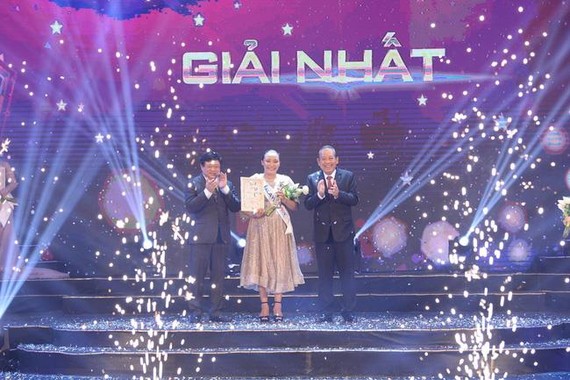 Deputy Prime Minister Truong Hoa Binh (R) presents first prize to Malaysian singer Rosario Ninih Chamini Bianis (Photo: VOV)