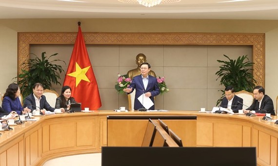 Deputy Prime Minister Vuong Dinh Hue (standing) addresses the meeting of the steering committee for pricing on January 31 (Photo: VNA)