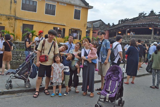Tourists visit Hoi An ancient town.
