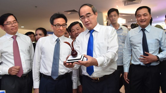 Secretary of Ho Chi Minh City Party Committee Nguyen Thien Nhan ( R ) and Deputy Prime Minister Vu Duc Dam see a souvenir craft product in a exhibition. (Photo: SGGP)