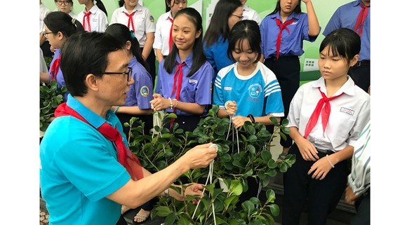 Child Protection Specialist, Tran Cong Binh hands over trees to students at the event. (Photo: SGGP)