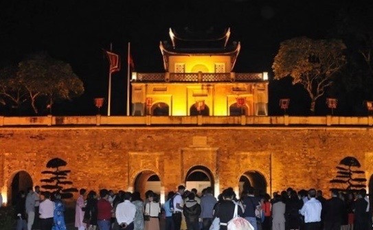 Visitors stand in front of Doan Mon (Main Gate) of the Thang Long Imperial Citadel in the evening (Photo: VNA)