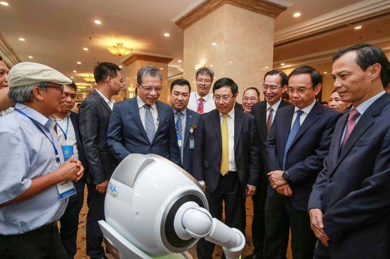 Deputy Prime Minister, Pham Binh Minh; and Secretary of the HCMC Party Committee, Nguyen Van Nen see exhibits at a display on high-tech products in the meeting. (Photo: SGGP)