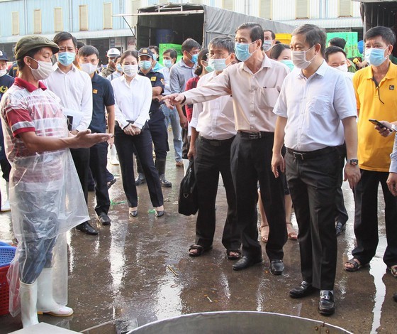 HCMC People's Committee Vice Chairman Duong Anh Duc leads a delegation to inspect the epidemic prevention and control at Binh Dien whosale market. (Photo: SGGP)