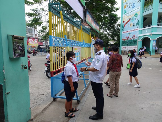 Học sinh Trường Tiểu học An Hội (quận Gò Vấp) được đo thân nhiệt ngay tại cổng trường