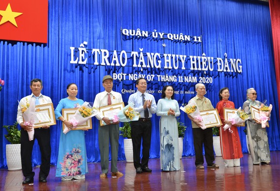 Đồng chí Nguyễn Thị Lệ, Phó Bí thư Thành ủy, Chủ tịch HĐND TPHCM trao huy hiệu Đảng cho các đảng viên tại quận 11. Ảnh: VIỆT DŨNG