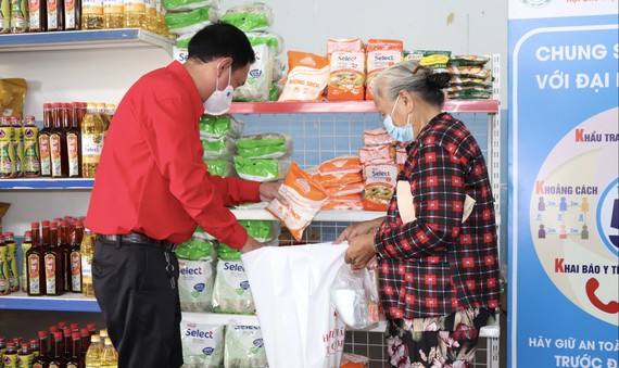 Chủ tịch Hội Chữ thập đỏ TPHCM Trần Trường Sơn giúp người dân chọn hàng tại Phiên chợ nhân đạo tại huyện Nhà Bè