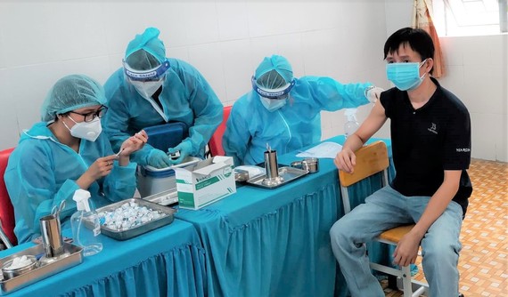 TPHCM: Hơn 90% dân số trên 18 tuổi đã tiêm mũi 1 vaccine Covid-19  Nhân viên y tế tiêm vaccine Covid-19 cho người dân