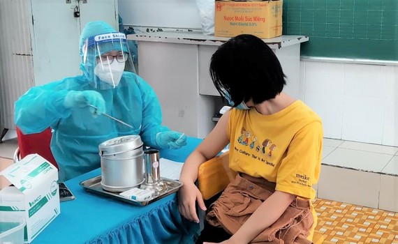 TPHCM: 98,6% người trên 18 tuổi đã tiêm 1 mũi vaccine, 4 quận huyện đã tiêm đủ 2 mũi Nhân viên y tế tiêm vaccine Covid-19 cho người dân