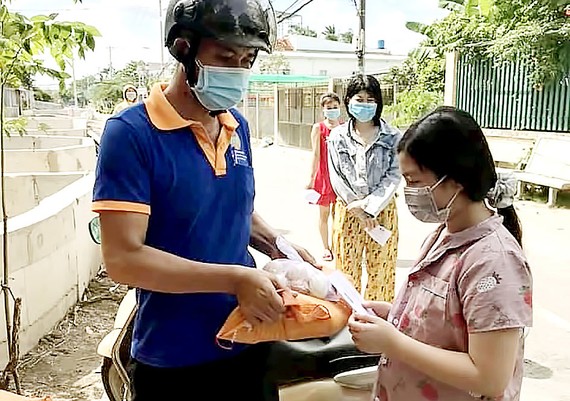 Triển khai gói hỗ trợ: Xác minh rõ, thực hiện nhanh Người lao động khó khăn do dịch Covid-19 nhận quà hỗ trợ. Ảnh: BÙI ANH TUẤN