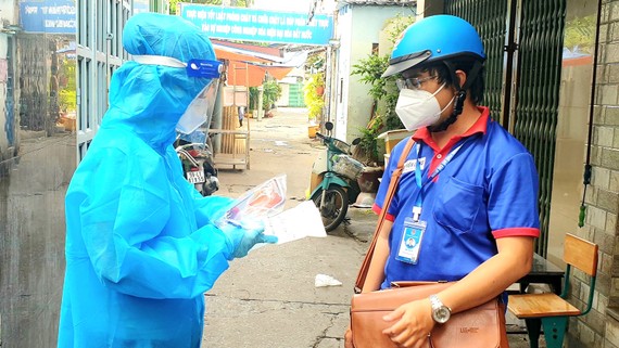 Góp sức trẻ cùng thành phố Anh Châu Tiến Lộc (phải), cán bộ Thành đoàn TPHCM, cùng nhân viên y tế nắm tình hình F0 điều trị tại nhà