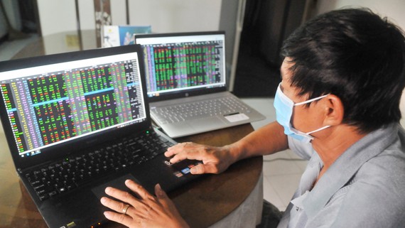 Thị trường chứng khoán thăng hoa Nhà đầu tư theo dõi giá cổ phiếu. Ảnh: CAO THĂNG