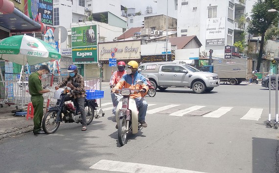 Tiến tới trạng thái “bình thường mới”: Đồng hành chống dịch, vượt khó Kiểm tra giấy tờ tại chốt kiểm soát Phan Bội Châu - Bạch Đằng, quận Bình Thạnh ngày 15-9. Ảnh: MINH NGHĨA