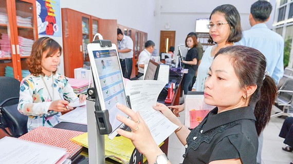 Hoàn thiện thể chế về kinh doanh và cạnh tranh Người dân đánh giá sự hài lòng về cải cách hành chính tại UBND quận 4, TPHCM. Ảnh: VIỆT DŨNG