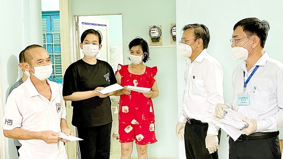 Dân vận bằng trái tim Trưởng Ban Dân vận Thành ủy TPHCM Nguyễn Hữu Hiệp (thứ 2 từ phải qua) thăm, động viên và trao quà hỗ trợ đến các hộ dân vừa tạm chuyển chỗ ở tới Nhà nghỉ Công đoàn Thanh Đa, quận Bình Thạnh