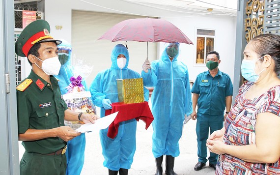 Tình quân dân, nghĩa đồng bào Các chiến sĩ lực lượng vũ trang TPHCM đưa tro cốt của người đã khuất vì dịch Covid-19 đến tận tay người thân tại địa bàn quận 8. Ảnh: HOÀNG HÙNG