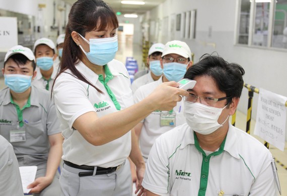 Từng bước thích nghi với điều kiện “bình thường mới” - Bài 5: Truyền “đạm” cho doanh nghiệp Đo thân nhiệt trước khi tiêm vaccine Covid-19 cho nhân viên Công ty Nidec (Khu công nghệ cao TPHCM). Ảnh: HOÀNG HÙNG