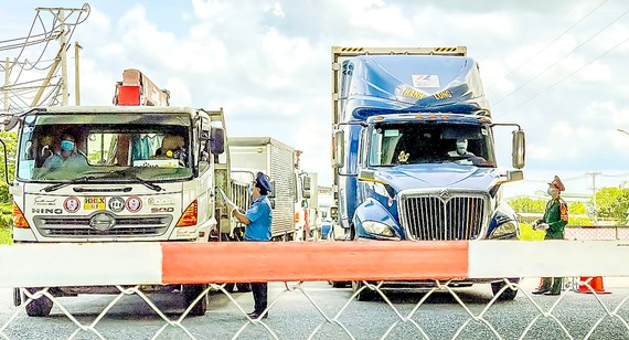 Các tỉnh Đông Nam bộ thống nhất phương án tổ chức giao thông của TPHCM Lực lượng chức năng kiểm tra giấy thông hành tại trạm Ngã 3 Làng QL1A - Bình Chánh, TPHCM. Ảnh: HOÀNG HÙNG