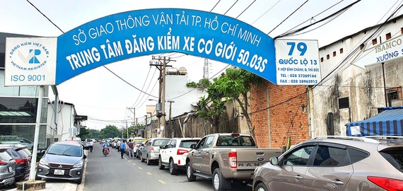 Quá tải đăng ký, đăng kiểm phương tiện Hàng trăm phương tiện ô tô sắp hàng trên quốc lộ 13 chờ đăng kiểm