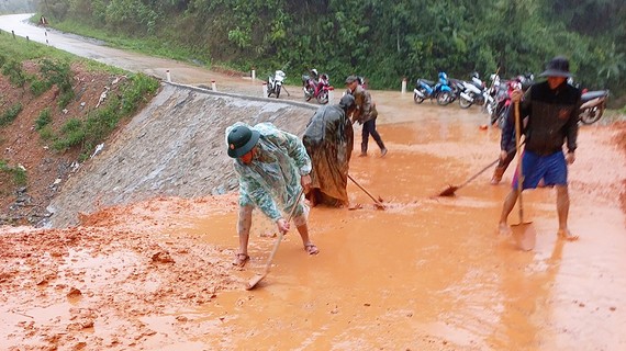 Miền Trung: Tập trung khắc phục hậu quả mưa lũ Bộ đội Biên phòng tỉnh Quảng Trị cùng người dân dọn bùn đất trên tuyến đường liên xã ở huyện Đakrông (Quảng Trị). Ảnh: NGUYỄN HOÀNG