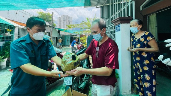 Chờ hỗ trợ gia đình người mất do Covid-19 Người thân nhận tro cốt người mất do Covid-19. Ảnh: VĂN MINH