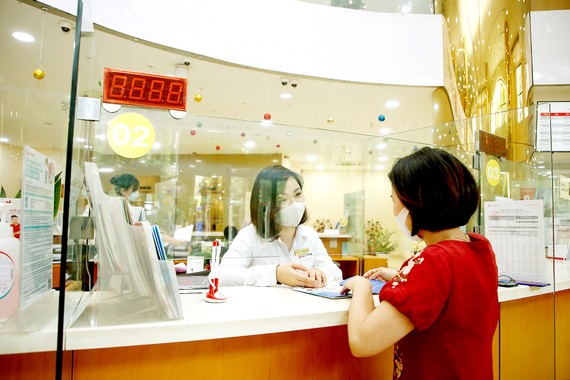 Nỗi lo gia tăng nợ xấu Giao dịch tại một ngân hàng ở TPHCM. Ảnh: HẠNH NHUNG