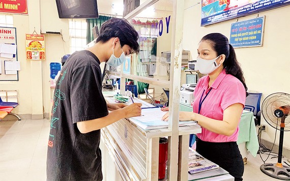 Nhọc nhằn xin giấy xác nhận tình trạng hôn nhân Người dân làm thủ tục hành chính tại một phường ở TPHCM. Ảnh: THÁI PHƯƠNG