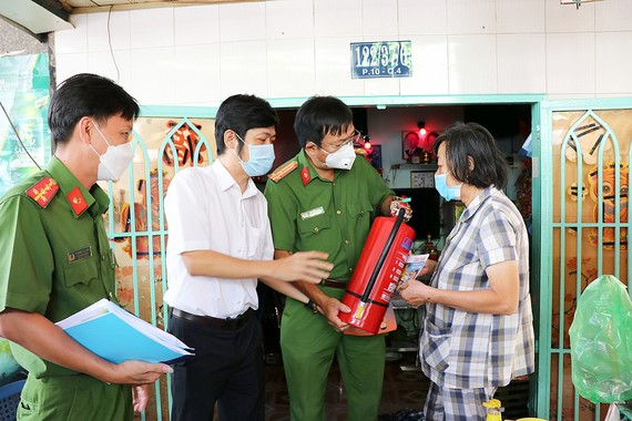 Chủ động phòng cháy ở khu dân cư Đoàn công tác Phòng PC07, Công an TPHCM tặng bình chữa cháy cho người dân ở quận 4