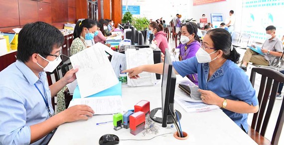 Cơ chế, chính sách đặc thù phát triển TPHCM: Nghị quyết 54 chưa như kỳ vọng Cán bộ UBND huyện Bình Chánh, TPHCM giải quyết hồ sơ hành chính cho người dân. Ảnh: VIỆT DŨNG