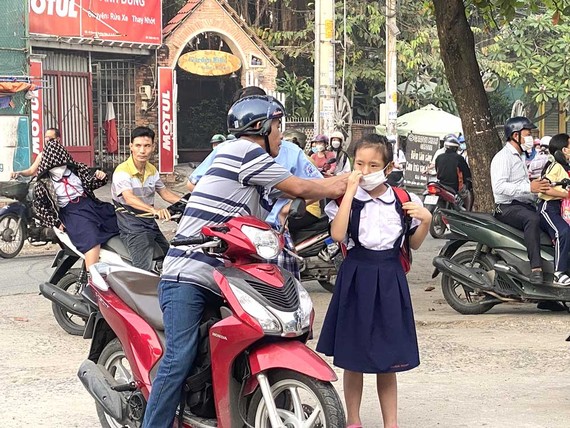 Lùi giờ học - bao nhiêu là đủ? Dù có quy định lùi giờ vào học nhưng nhiều phụ huynh của Trường Tiểu học Nguyễn Viết Xuân (quận Gò Vấp, TPHCM) vẫn tranh thủ đưa con đến lớp từ sớm. Ảnh: BÙI TUẤN