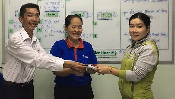 Bà Đoan (giữa) trao trả lại tiền cho chị Nguyễn Thị Thùy Dương
