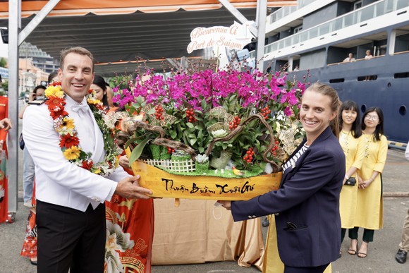 Đại diện du thuyền nhận hoa từ ngành du lịch TPHCM với thông điệp "Thuận buồm xuôi gió". Ảnh: HOÀNG HÙNG