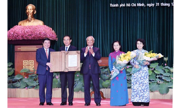 Phó Chủ tịch Quốc hội Uông Chu Lưu trao Nghị quyết của Ủy ban Thường vụ Quốc hội về việc sắp xếp các đơn vị hành chính cấp huyện, cấp xã và thành lập TP Thủ Đức thuộc TPHCM cho lãnh đạo TPHCM. Ảnh: VIỆT DŨNG