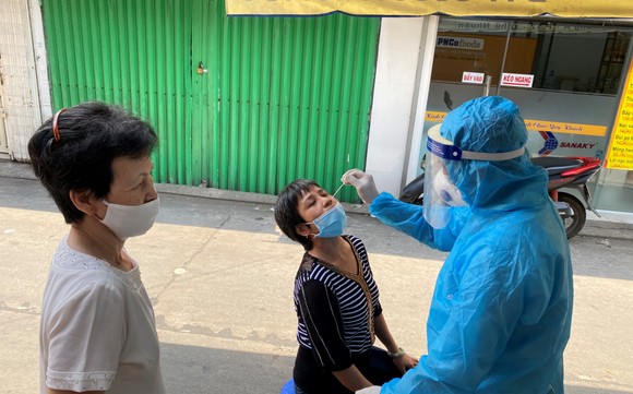 Nhân viên y tế lấy mẫu xét nghiệm cho người dân ở khu vực đường Cao Thắng, phường 17, quận Phú Nhuận, TPHCM. Ảnh: CAO THĂNG