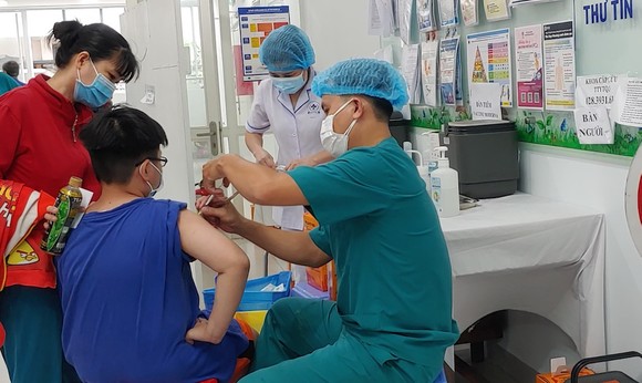 Nhân viên y tế tiêm vaccine Covid-19 cho trẻ
