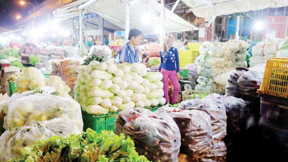 Kinh doanh rau tại chợ đầu mối nông sản Hóc Môn. Ảnh: Quốc Sơn