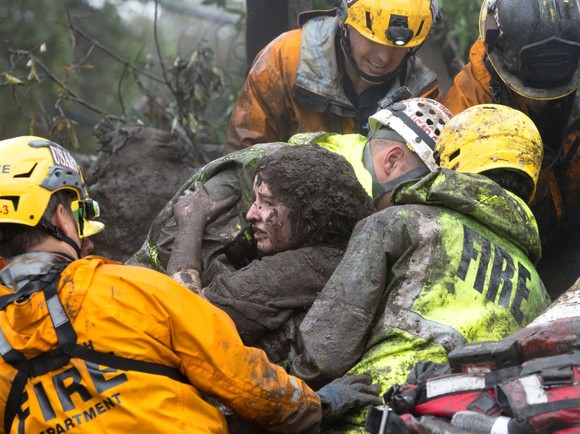 緊急救援人員從坍塌的家裡救出一名渾身裹滿泥土的女子。（圖源：路透社）
