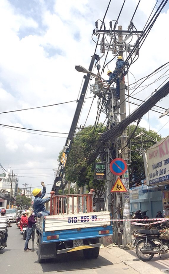 西貢電力公司工人在第三郡八月革命街 進行保養晉級電線網。