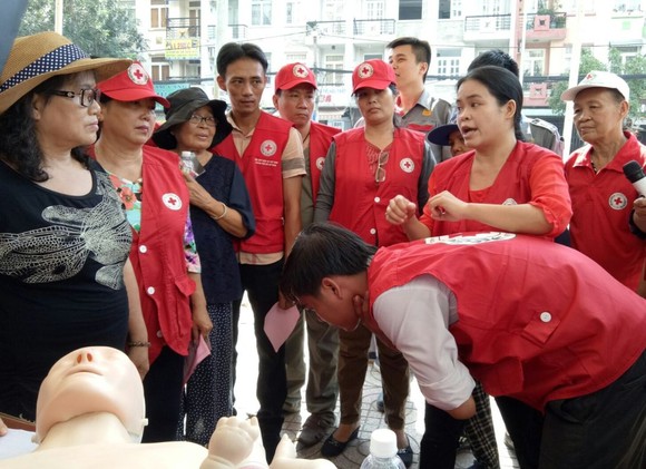 紅十字會人員指引民眾被異物卡住喉嚨的急救方法。