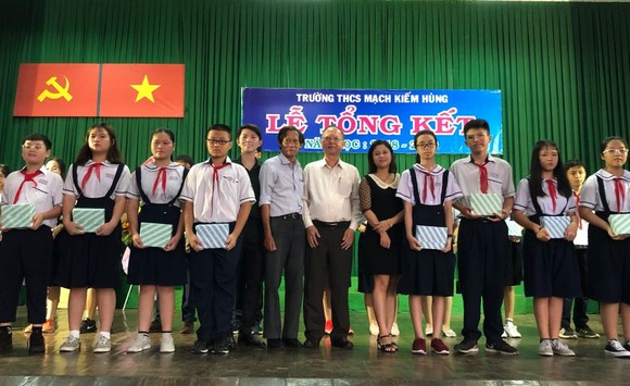 穗城會館理事長盧耀南(左七)向麥劍雄學校優秀學生頒獎。