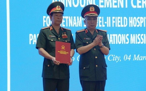 阮志詠上將（右）代表中央軍委及國防部領導頒授國防部長的3號二級野戰醫院成立與責成任務《決定》。（圖源：成山）