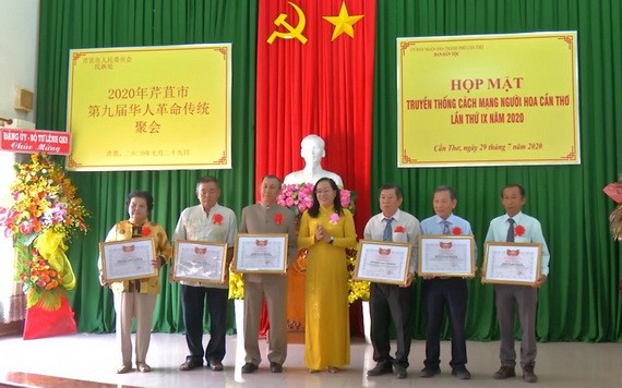 芹苴市越南祖國陣線委員會副主席阮翠姮（中）向華人同胞集體典範代表頒發獎狀。（圖源：芹苴電視台）