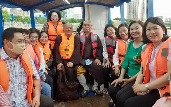 釋慧功法師與市越南祖國陣線委員會領導坐船考察豆腐涌。