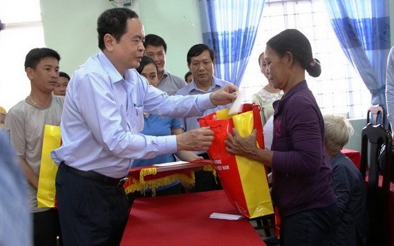 越南祖國陣線中央委員會主席陳清敏向廣義省災民表示親切慰問並贈送禮物。（圖源：明軍） 