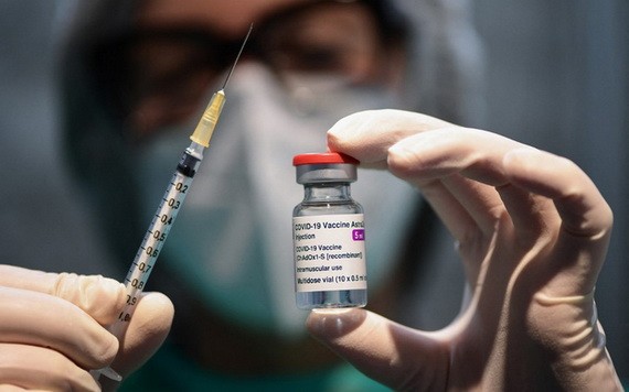 圖為醫務人員拿著一個注射器和一小瓶 AstraZeneca 新冠病毒疫苗。（圖源：AFP）